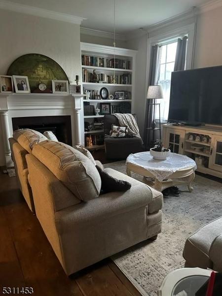 living room featuring crown molding and dark hardwood / wood-style floors