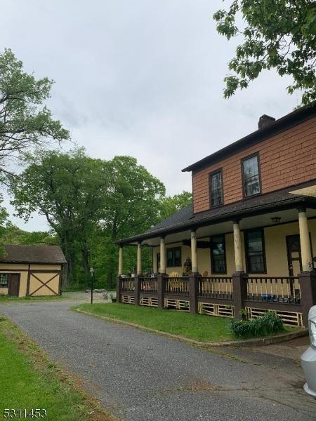 view of front facade featuring a porch and a storage shed