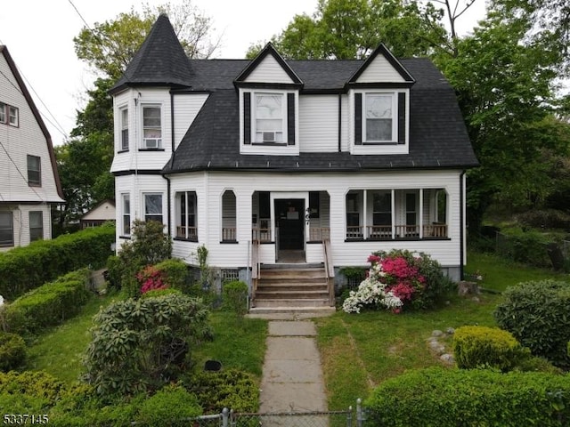 victorian home with a porch and a front lawn