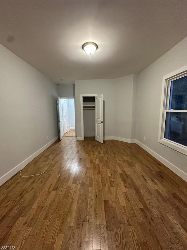 unfurnished bedroom featuring hardwood / wood-style flooring and a closet