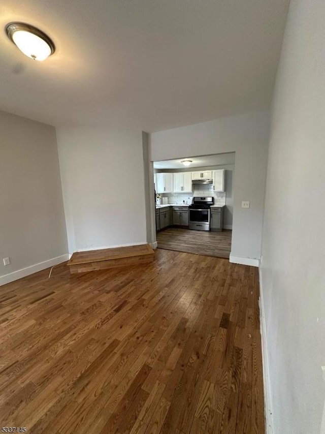 unfurnished living room with dark wood-type flooring