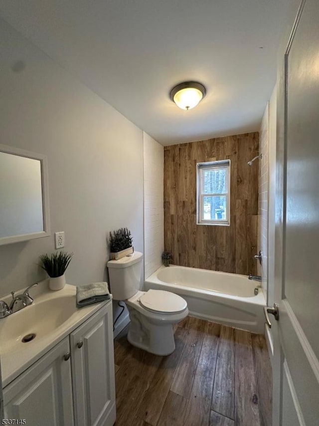 full bathroom with tiled shower / bath, hardwood / wood-style floors, vanity, and toilet