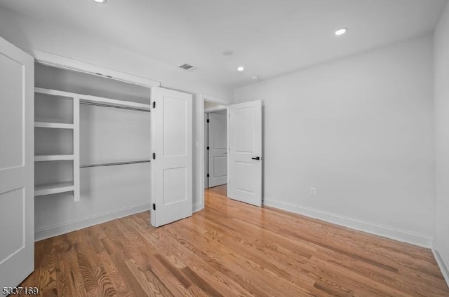 unfurnished bedroom with wood-type flooring and a closet