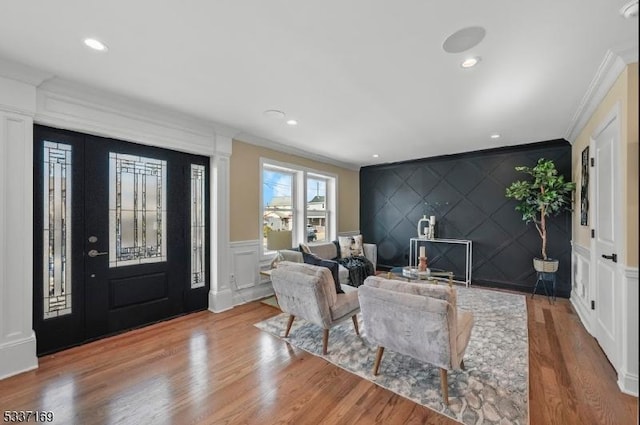 entryway featuring hardwood / wood-style flooring, ornamental molding, and ornate columns