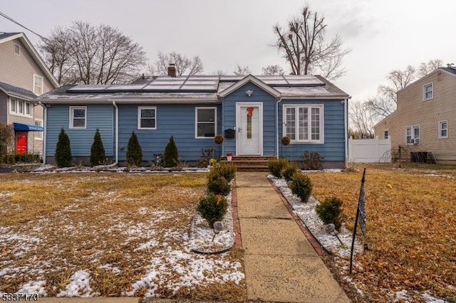 view of front of house featuring a front yard and solar panels