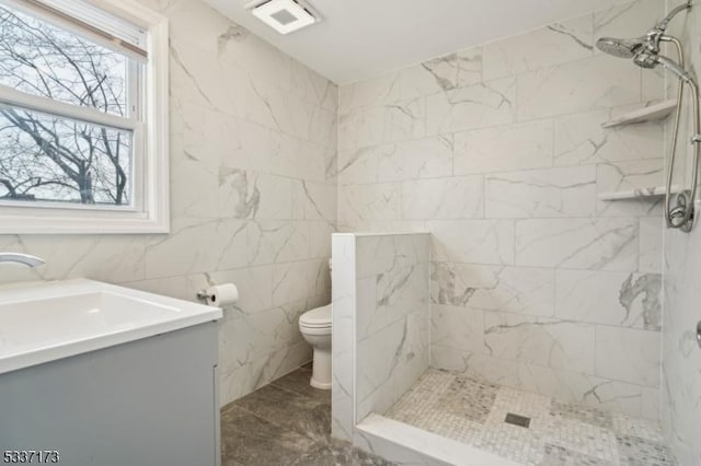 bathroom featuring vanity, toilet, and a tile shower