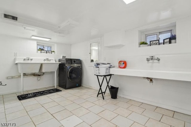 clothes washing area featuring washer / clothes dryer and sink