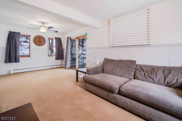 living room with beam ceiling, a baseboard heating unit, ceiling fan, a textured ceiling, and light carpet