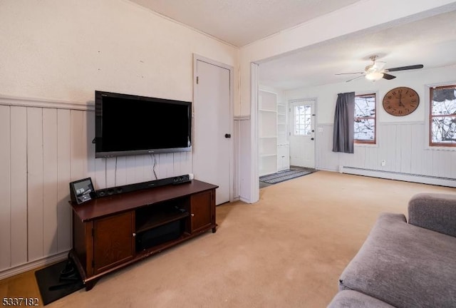 living room with light carpet, plenty of natural light, ceiling fan, and a baseboard heating unit