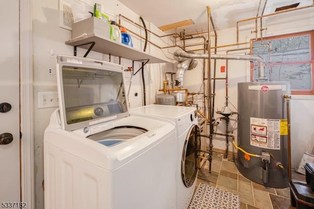 clothes washing area featuring gas water heater and washer and clothes dryer