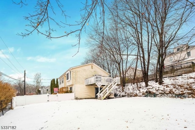 view of snowy exterior with a wooden deck