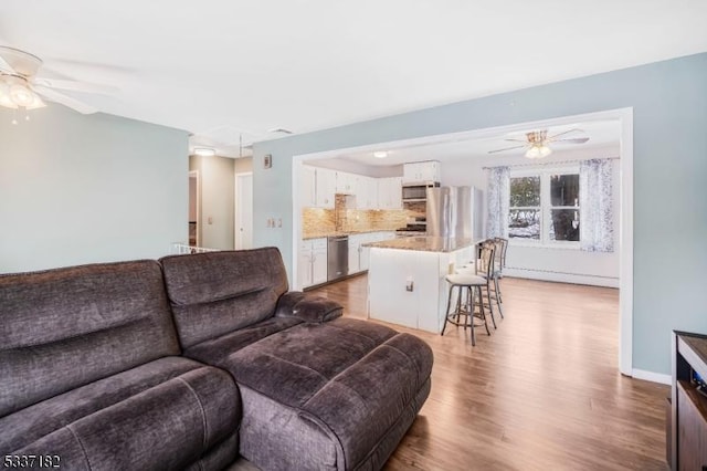 living room featuring hardwood / wood-style floors and ceiling fan