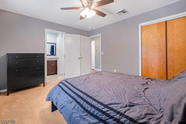 carpeted bedroom with ceiling fan and ensuite bath