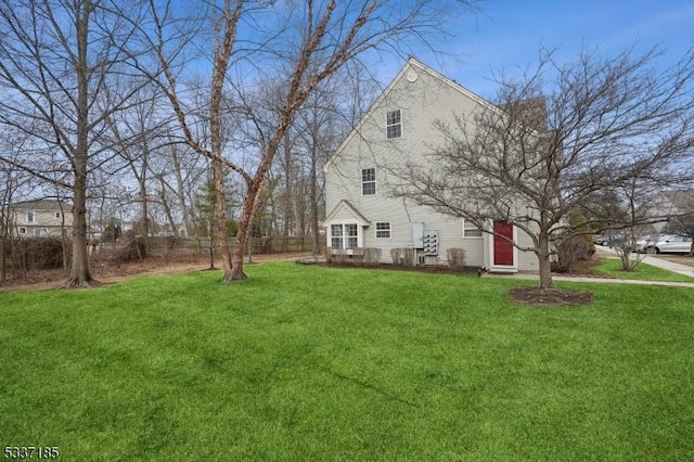 view of side of property with a lawn and fence