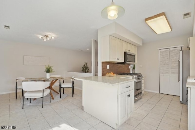 kitchen with light tile patterned floors, visible vents, backsplash, and appliances with stainless steel finishes