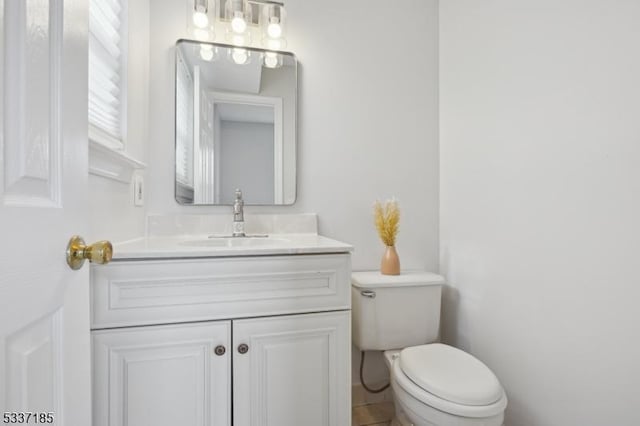 half bathroom featuring toilet and vanity