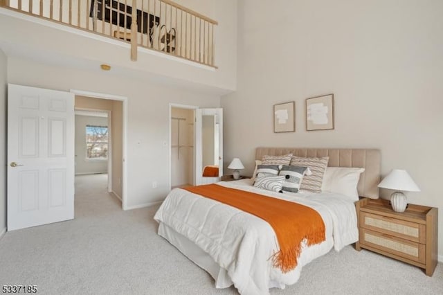 carpeted bedroom featuring baseboards and a towering ceiling