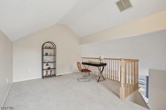 interior space featuring lofted ceiling, baseboards, visible vents, and carpet floors