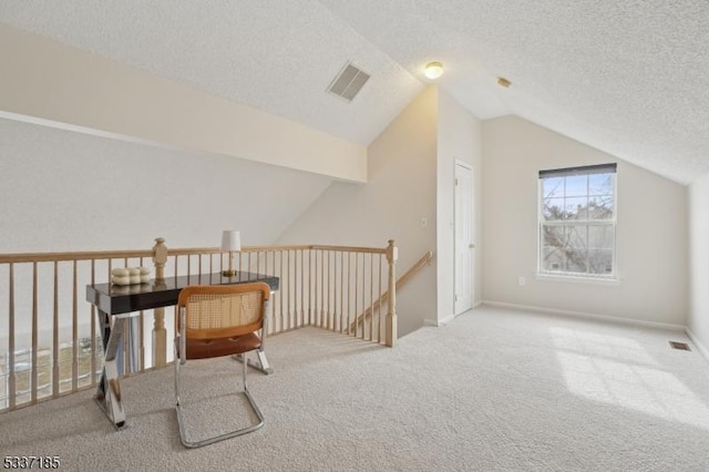 interior space featuring lofted ceiling, carpet flooring, visible vents, and a textured ceiling