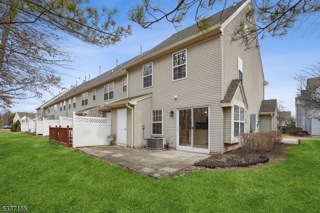 rear view of house with a patio, a lawn, central AC unit, and fence