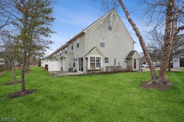 rear view of property with a yard, central air condition unit, and a patio