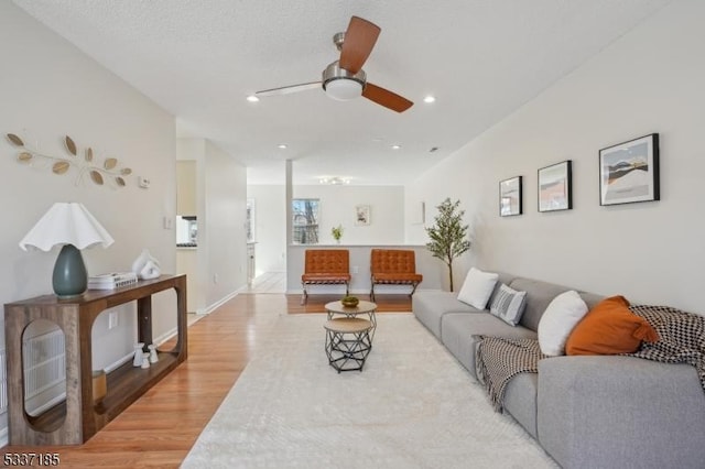 living room with recessed lighting, a ceiling fan, light wood-type flooring, and baseboards