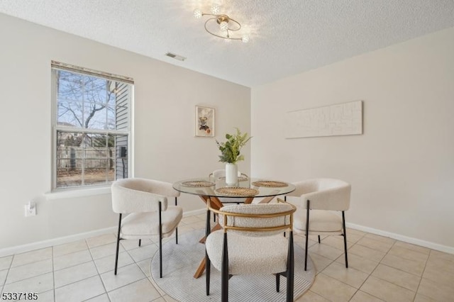 dining space featuring visible vents, baseboards, breakfast area, light tile patterned floors, and a textured ceiling