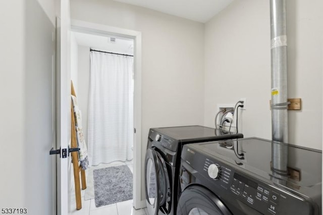 washroom with light tile patterned floors and washing machine and clothes dryer