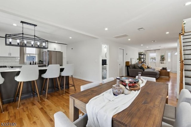 dining space featuring a chandelier and light wood-type flooring