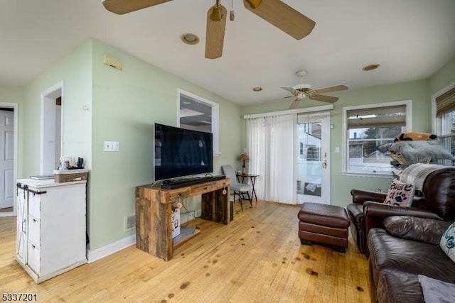 living room featuring light hardwood / wood-style floors and ceiling fan