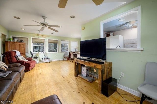 living room featuring light hardwood / wood-style flooring and ceiling fan