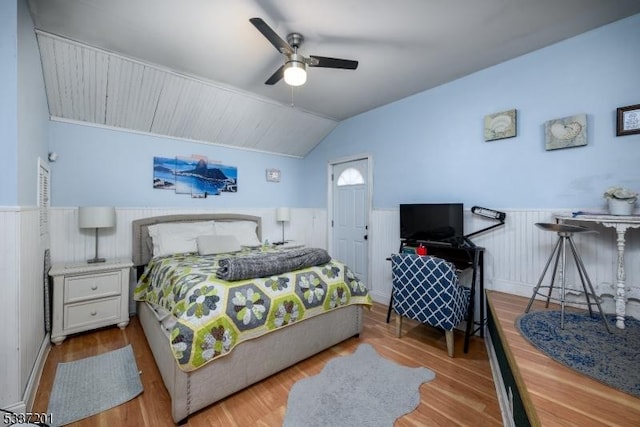 bedroom with ceiling fan, light hardwood / wood-style floors, and vaulted ceiling