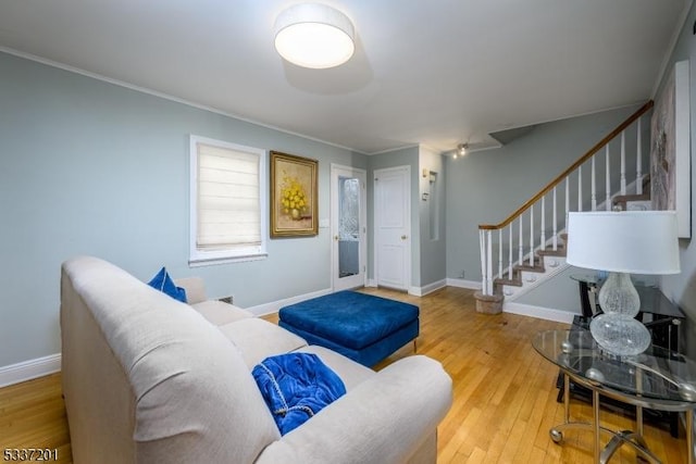 living room featuring hardwood / wood-style flooring and crown molding