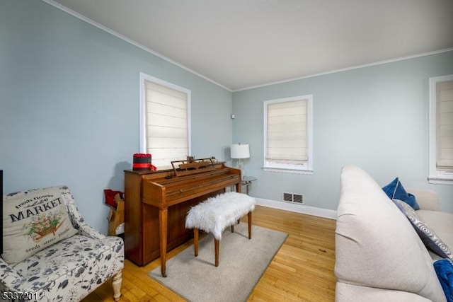 living area featuring hardwood / wood-style flooring and crown molding