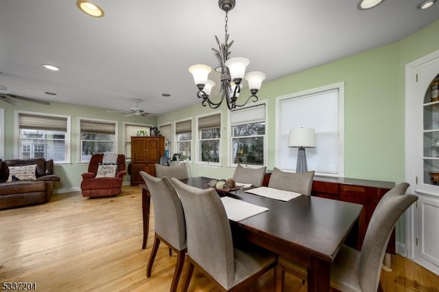 dining area with plenty of natural light, ceiling fan with notable chandelier, and light wood-type flooring