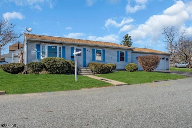 single story home featuring a garage, a front yard, and aphalt driveway