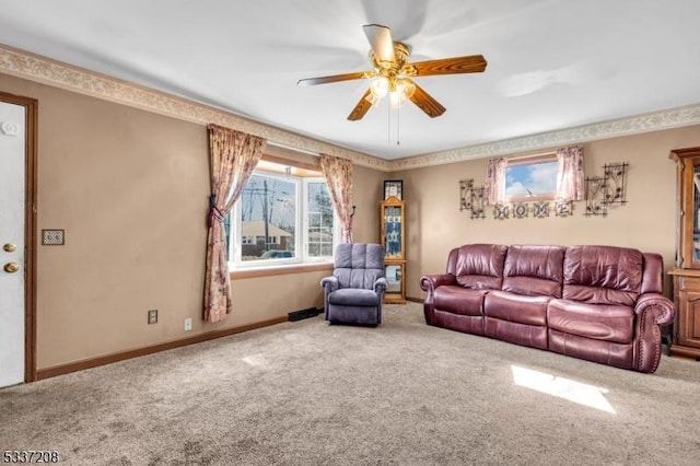 carpeted living area with a ceiling fan and baseboards