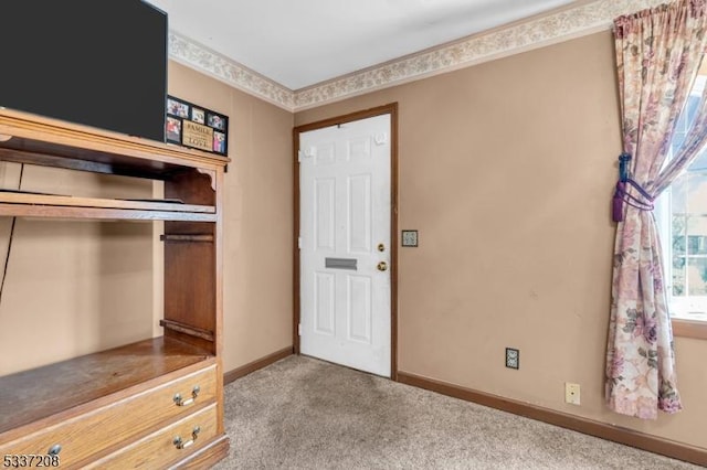 foyer entrance with baseboards and carpet floors