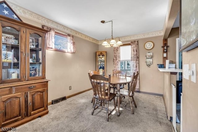 dining room featuring visible vents, baseboards, light colored carpet, and a notable chandelier