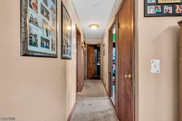 hallway with carpet flooring and baseboards