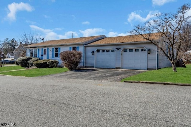 ranch-style home with a garage, driveway, and a front lawn