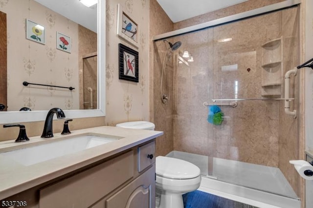 bathroom with vanity, toilet, and a shower stall