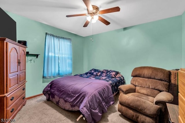 carpeted bedroom featuring baseboards and ceiling fan