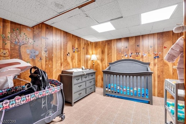 bedroom with wood walls and a paneled ceiling