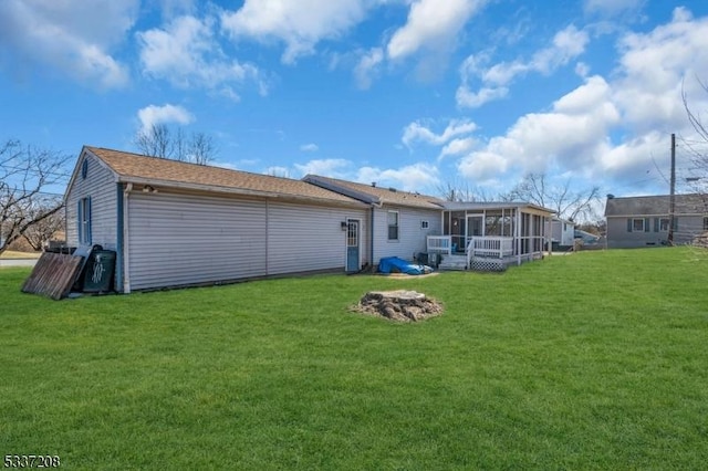 back of house featuring a lawn and a sunroom