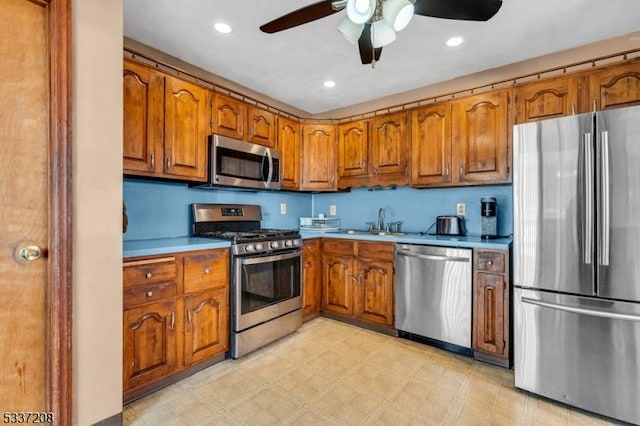 kitchen with recessed lighting, brown cabinets, appliances with stainless steel finishes, and light floors