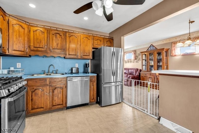 kitchen featuring a sink, stainless steel appliances, brown cabinets, and light countertops