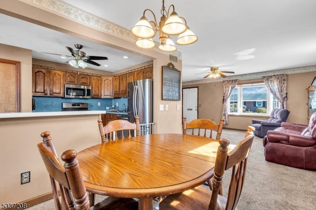 dining room featuring visible vents, light colored carpet, ceiling fan with notable chandelier, and baseboards