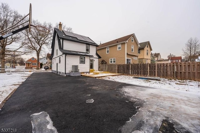 snow covered house with central AC and solar panels