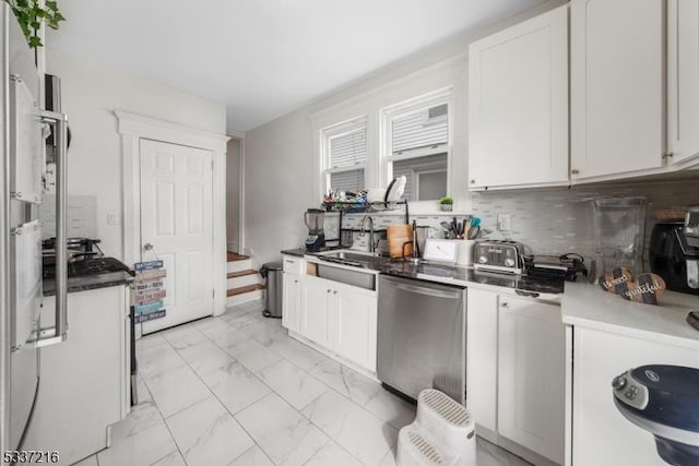 kitchen featuring dishwasher, sink, white cabinets, and decorative backsplash